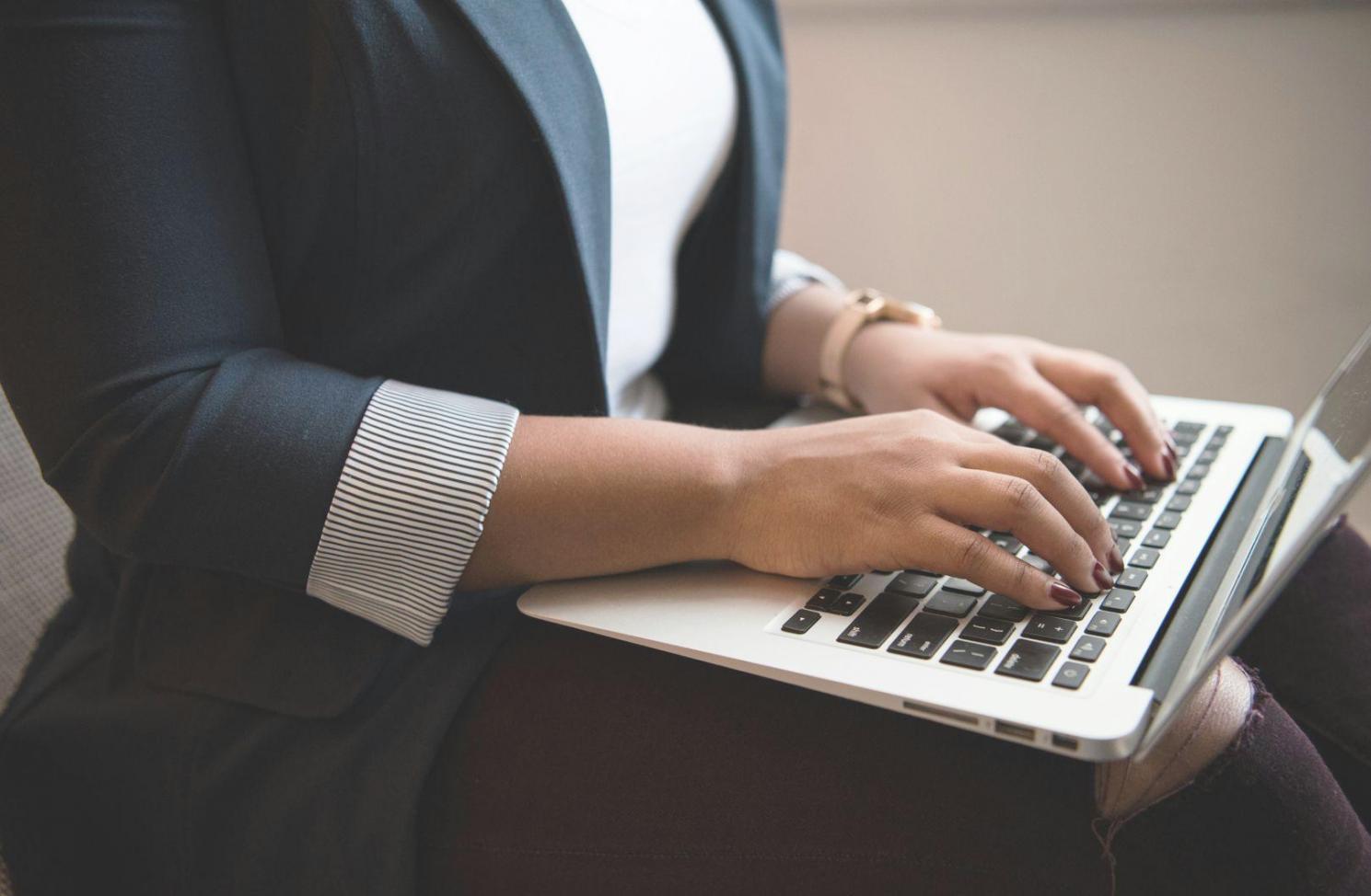Students learning budget analysis techniques on laptops